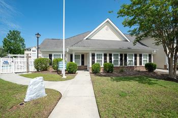 A house with a white picket fence in front.